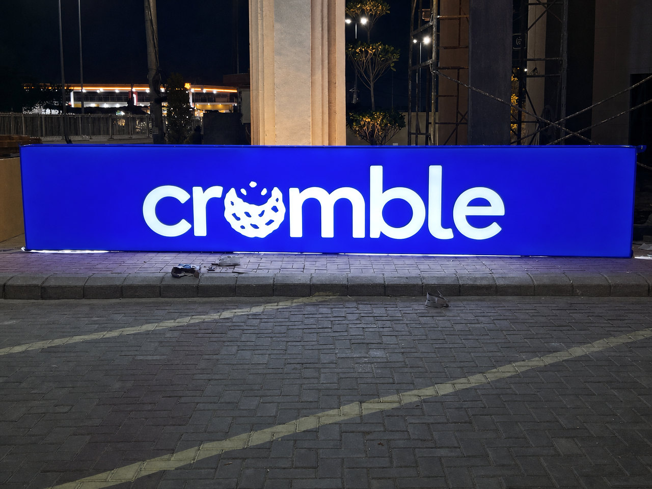 Illuminated CRUMBLE signboard photographed at night after installation